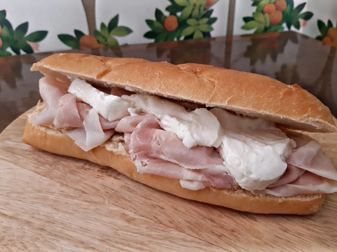 Panino sur ciabatta devant le mur d’azulejos de la boutique